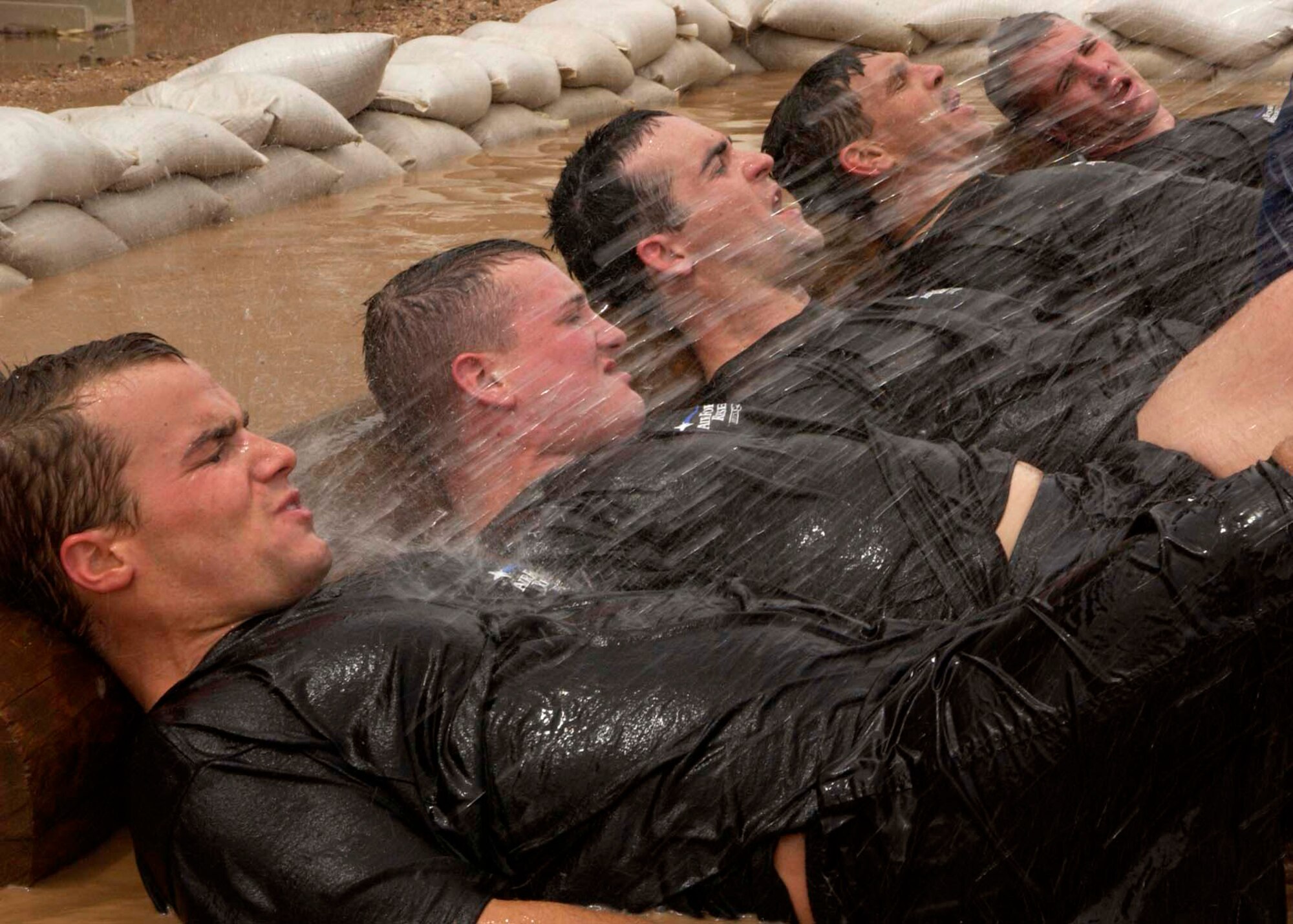 Military and civilian applicants taking part in the 306th Rescue Squadron pararescue screening perform flutter kicks in a mud pit at Davis-Monthan Air Force Base, Ariz., on Friday, April 21, 2006. Applicants must pass a timed 3-mile run, 1,500-meter swim, calisthenics and other tasks before proceeding to the 10-week indoctrination course at Lackland AFB, Texas. (U.S. Air Force photo/Airman 1st Class Veronica Pierce)