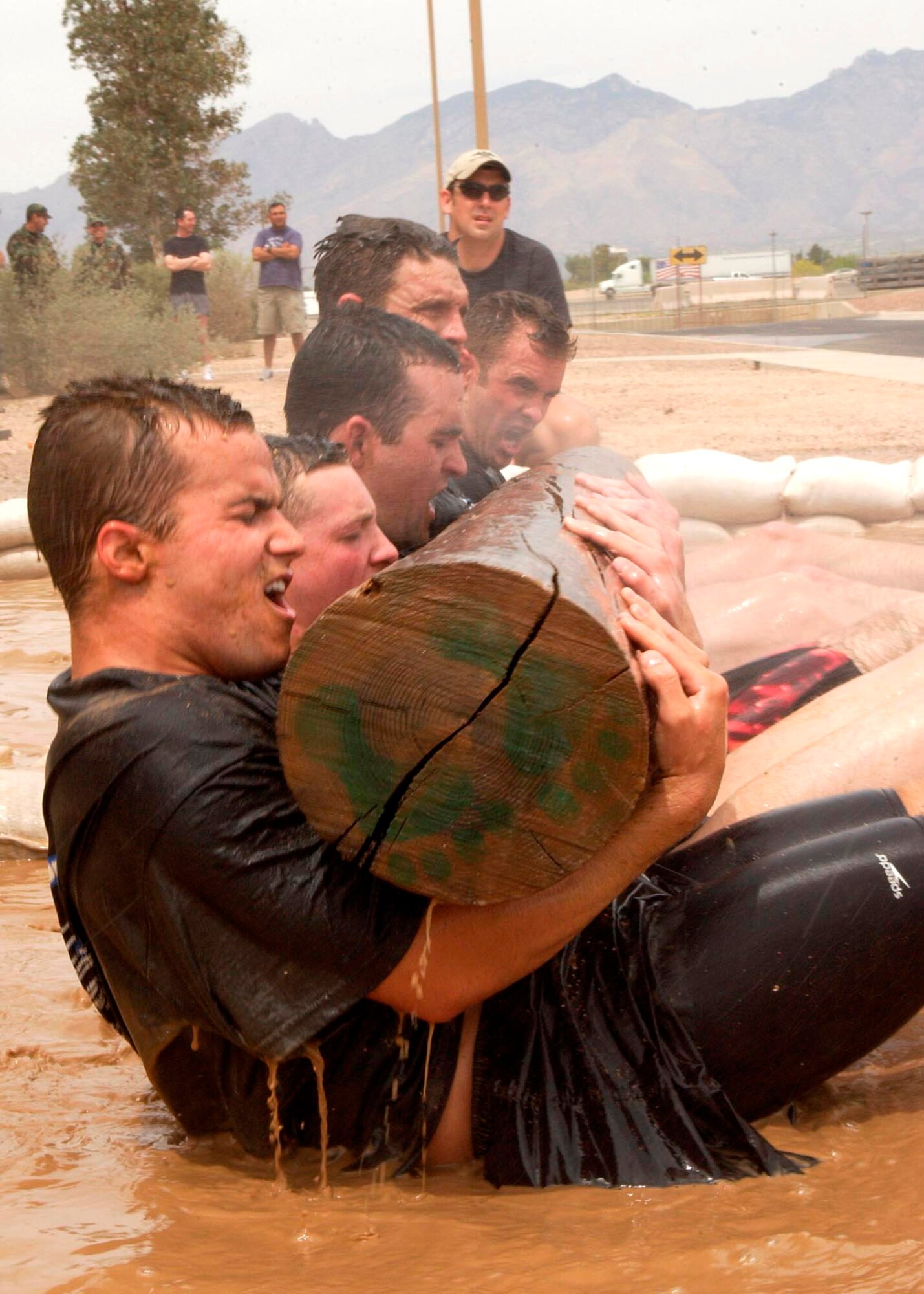 Military and civilian applicants taking part in the 306th Rescue Squadron pararescue screening do sit-ups in a mud pit while holding a wooden log at Davis-Monthan Air Force Base, Ariz., on Friday, April 21, 2006. Applicants must pass a timed 3-mile run, 1,500-meter swim, calisthenics and other tasks before proceeding to the 10-week indoctrination course at Lackland AFB, Texas. (U.S. Air Force photo/Airman 1st Class Veronica Pierce)
