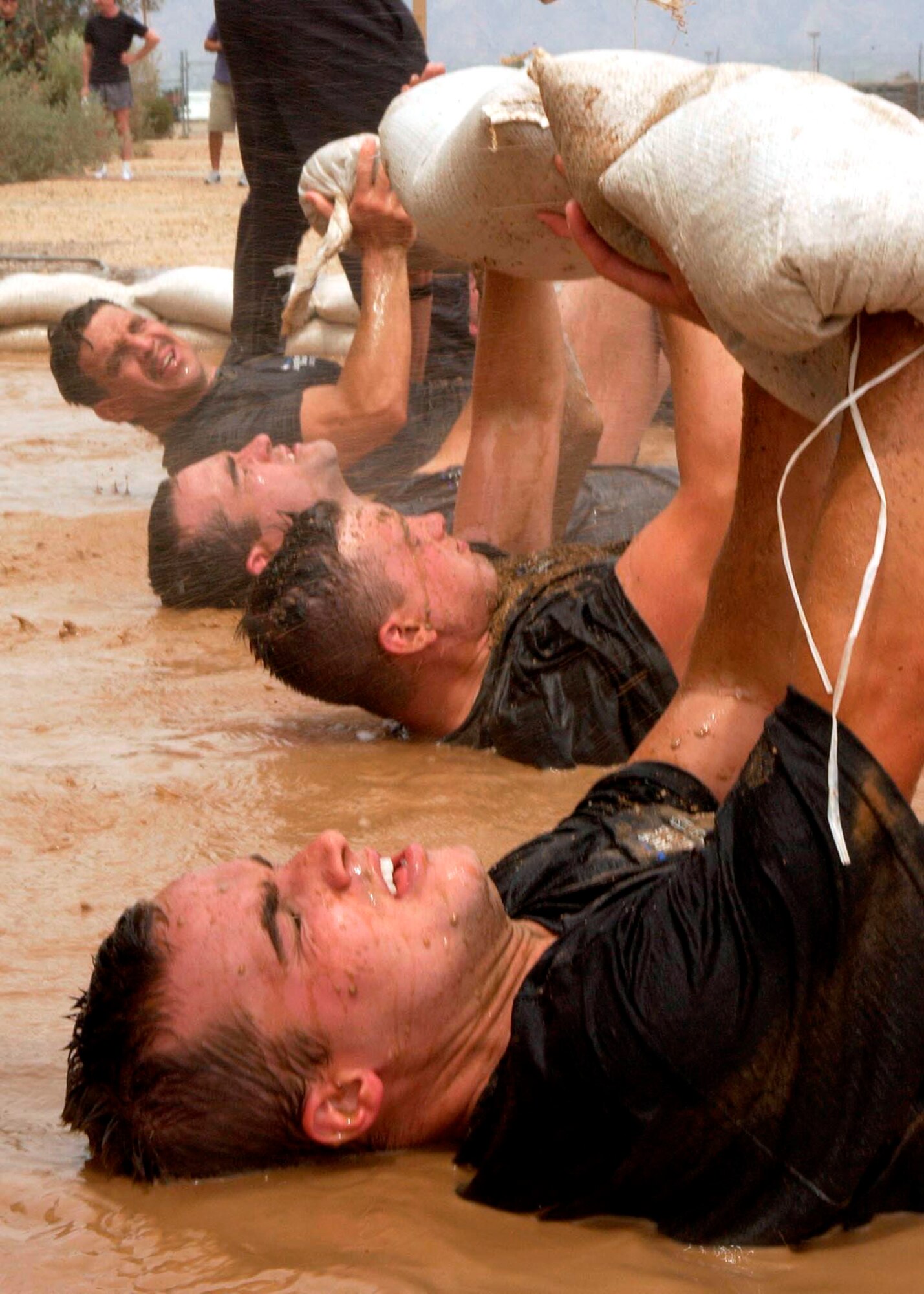 Alan Brumfield holds a sand bag over his chest while lying in a mud pit along with other military and civilian applicants during the 306th Rescue Squadron pararescue screening at Davis-Monthan Air Force Base, Ariz., on Friday, April 21, 2006. Applicants must pass a timed 3-mile run, 1,500-meter swim, calisthenics and other tasks before proceeding to the 10-week indoctrination course at Lackland AFB, Texas.  (U.S. Air Force photo/Airman 1st Class Veronica Pierce) 