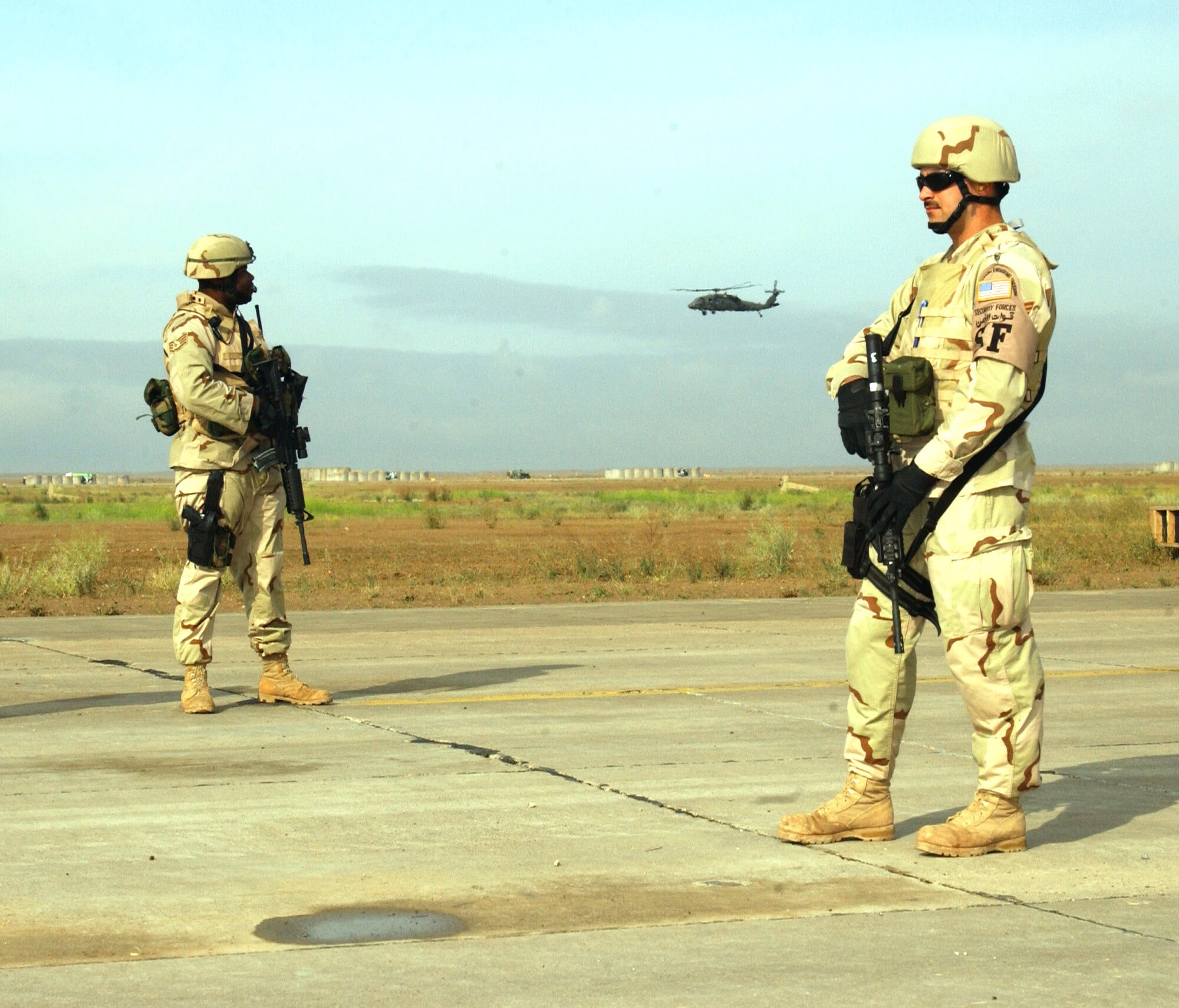 Tech. Sgt. Lukas Parr (right) and Staff Sgt. Kenneth Gordon watch for potential security problems while their C-130 Hercules is on the ground. They are members of the 332nd Expeditionary Security Forces Squadron fly-away security team. (U.S. Air Force photo/Tech Sgt. Steve Horton)
