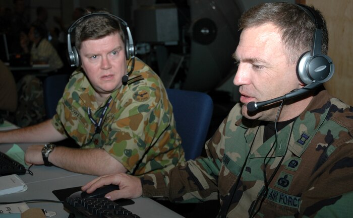 Royal Australian Air Force Squadron Leader Ken Bowes (left) works with Capt. Michael Cronin in the combined air and space operations center at Joint Expeditionary Force Experiment 2006 at Nellis Air Force Base, Nev. (U.S. Air Force photo/Maj. Richard Johnson)