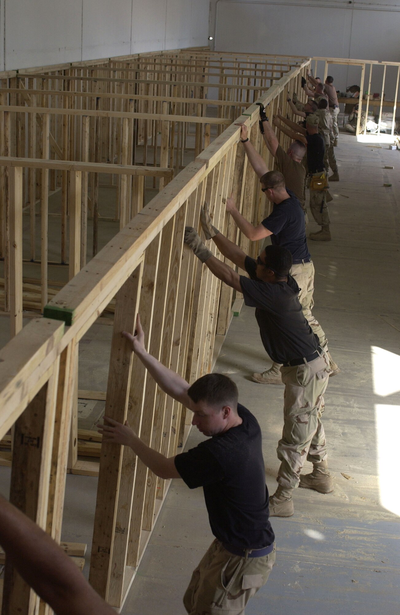 Airmen from the 557th Expeditionary Red Horse Squadron position a wall during renovation of an office building at Balad Air Base, Iraq, on Thursday, April 20, 2006. (U.S. Air Force photo/Tech. Sgt. Denise Rayder)


