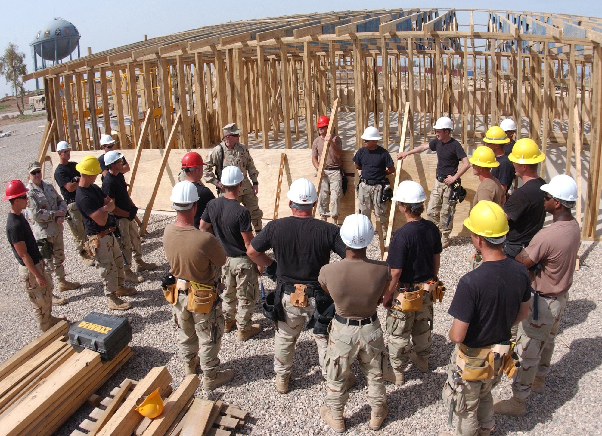 Chief Master Sgt. Layton Clark speaks with a structures team while they take a break from working on a 7,200-square-foot building for the U.S. State Department at Forward Operating Base Marez, Iraq, on Wednesday, April 26, 2006. Chief Clark is the 332nd Air Expeditionary Wing command chief. (U.S. Air Force photo/Airman 1st Class Jason Ridder)                  