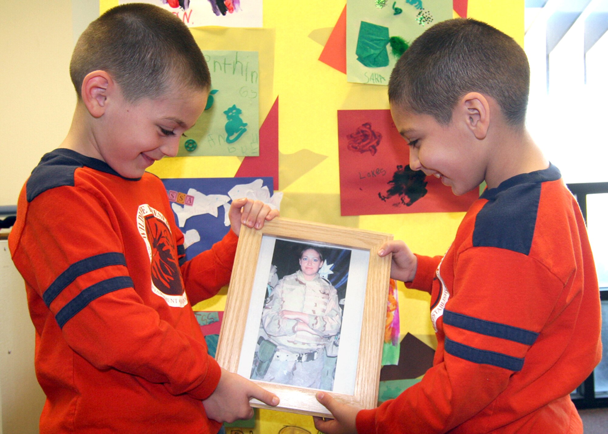 Damon and Kaden Koskovich, 6-year-old twins, hold a picture of their mother, Staff Sgt. Melissa Koskovich, at the child development center at Mountain Home Air Force Base, Idaho, on Tuesday, April 25, 2006. Sergeant Koskovich is currently deployed from Mountain Home to the U.S. Central Command area of operations in Southwest Asia.  (U.S. Air Force photo/Senior Airman Brian Stives)