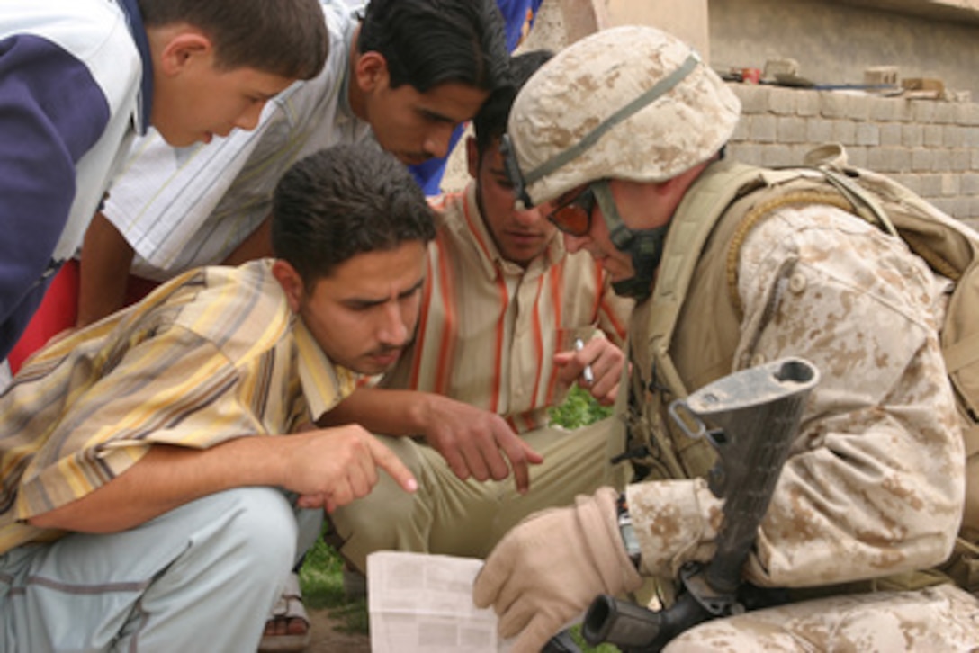 U.S. Marine Capt. Matthew M. Hodges asks a group of Iraqi students about weapons while patrolling through Saqlawyia, Iraq, on April 16, 2006. Hodges is the platoon commander of 4th Platoon, Alpha Company, 1st Battalion, 25th Marines, Regimental Combat Team 5. 