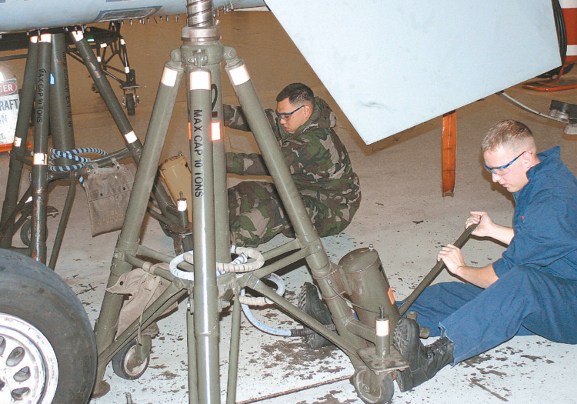 CANNON AIR FORCE BASE, N.M. - Staff Sgt. Dwayne Galan (left) and Senior Airman George McMillen, 27th EMS, perform a jacking operation on the rear section of the aircraft. The aircraft jacking procedure is performed in unison to ensure that the aircraft remains stable and both sides are raised at the same rate of ascent. (U.S. Air Force photo by Staff Sgt. Craig Seals)