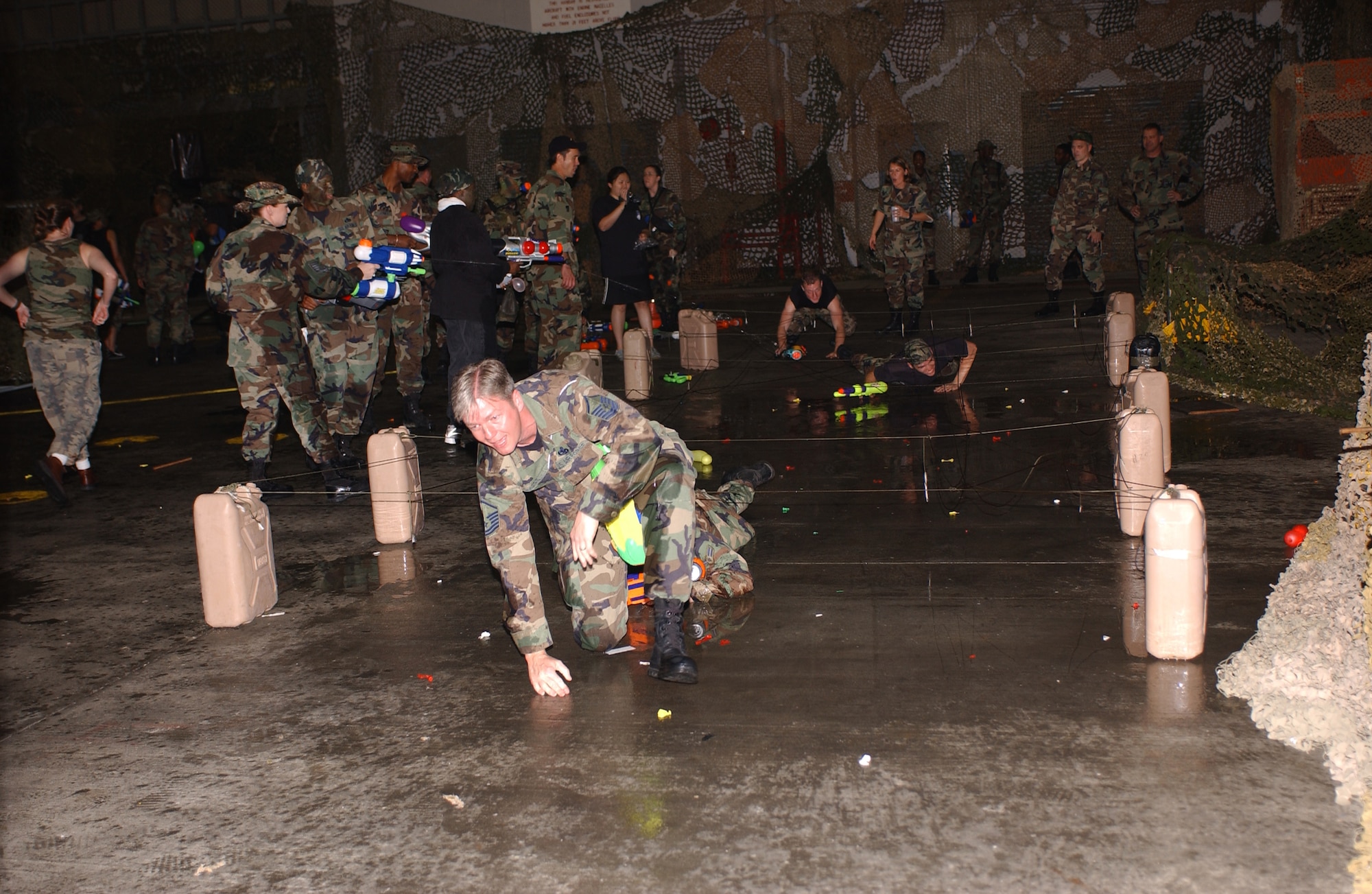 Master Sgt. Clint Rogers from the 320th Special Tactics Squadron gets through the low crawl portion of the obstacle course leading to the 353rd Special Operations Group Combat Dining Out.  The dining out was held in conjunction with the 26th anniversary of Operation Eagle Claw.                      