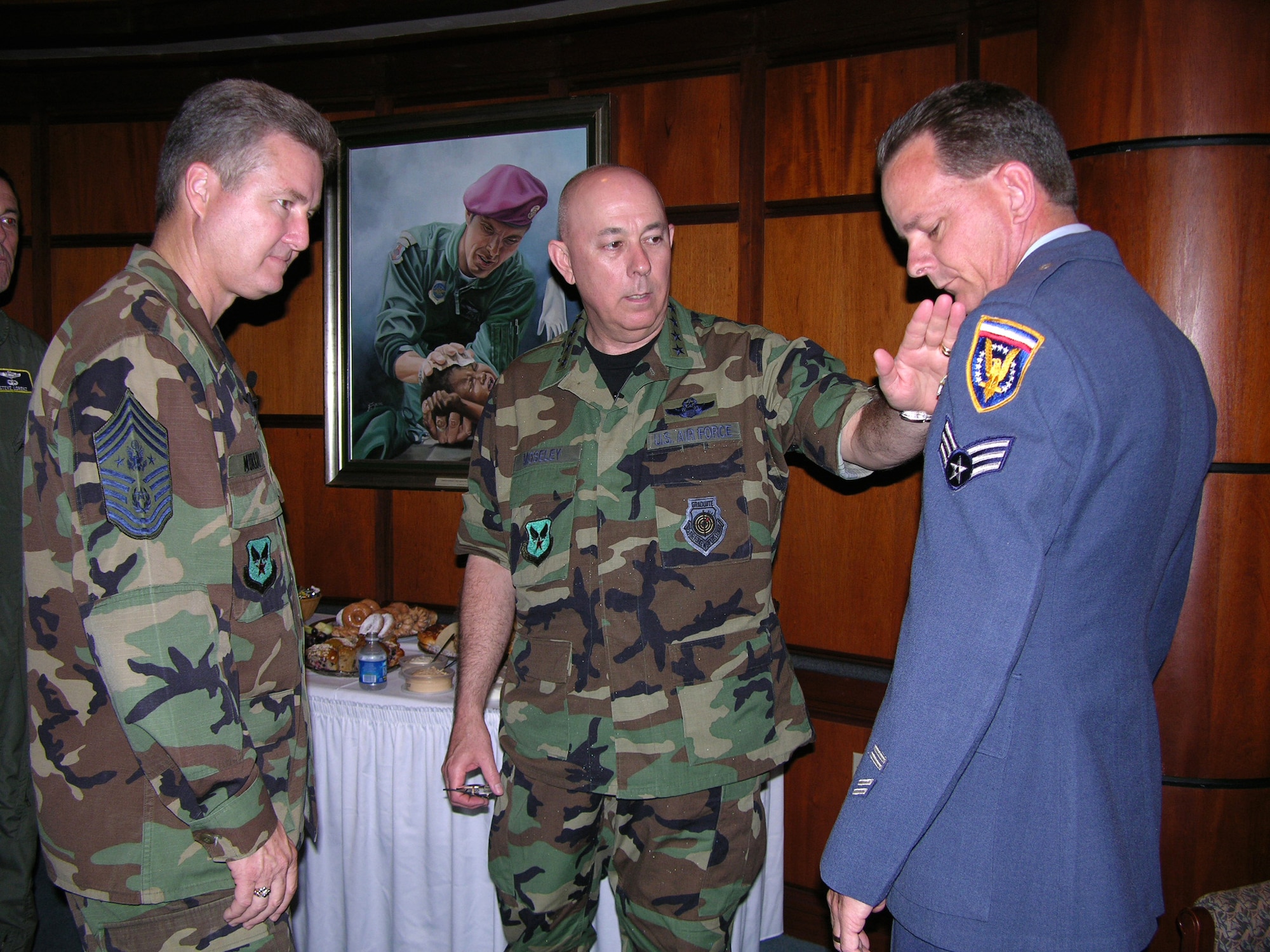 Gen. T. Michael Moseley, Air Force chief of staff, discusses changes to the uniform with Chief Master Sgt. of the Air Force Gerald R. Murray during the 2006 Worldwide Command Chiefs Conference at the Air Force Senior NCO Academy, Gunter Annex, Ala., on Wednesday, April 26, 2006. Some of the changes applied to the new uniforms will come from the look of the first Air Force uniform, worn here by Chief Master Sgt. Malcolm McVicar, Enlisted Heritage Hall director. (U.S. Air Force photo/Carl Bergquist)