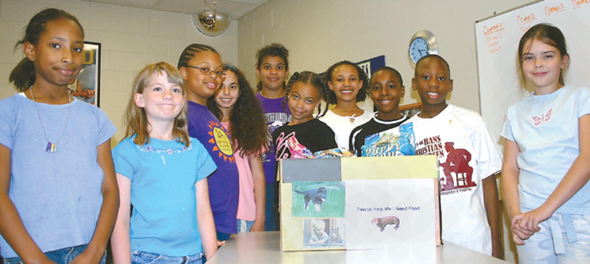 CANNON AIR FORCE BASE, N.M. - Members of Cannon's Torch Club gather around a box of animal food they donated to the Clovis Animal Shelter April 19. The club is for "tween"agers, from nine to 12 years old at the Cannon youth center. The club started in February and meets at 4 p.m. on Wednesdays. It reinforces service to the community and provides education and fitness guidelines in a social atmosphere. For more information, contact Thomasine Darnes at 784-2747. (U.S. Air Force photo by Janet Taylor-Birkey)