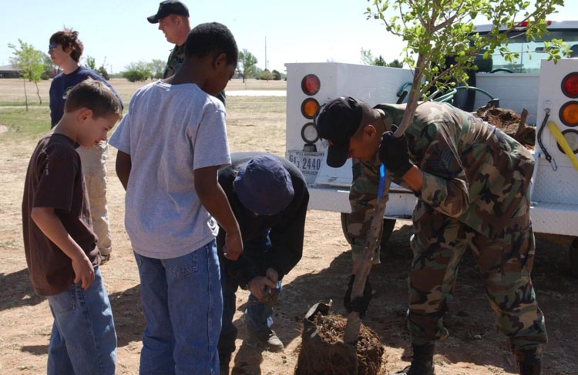CANNON AIR FORCE BASE, N.M. - Staff Sgt. Jose Guardiola, 27th  Civil Engineer Squadron, plants a tree at Doc Stewart Park April 19 as part of Earth Day activities conducted by Cannon Airmen and students from Ranchvale Elementary. (U.S. Air Force photo by Staff Sgt. April Wickes)
