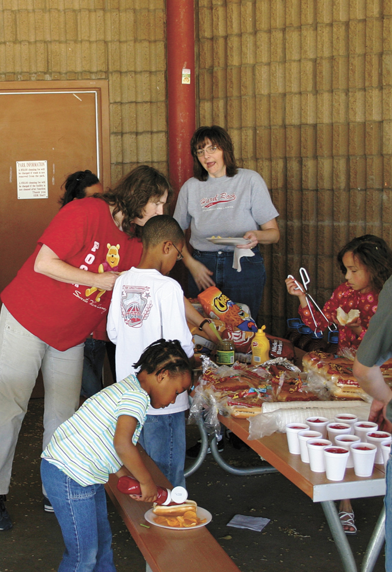 CANNON AIR FORCE BASE, N.M. - Families from the 27th Medical Group line up for free hot dogs and drinks under the pavilion at Unity Park. Volunteers assisted with the cooking and activities. (U.S. Air Force photo by Staff Sgt. Craig Seals)