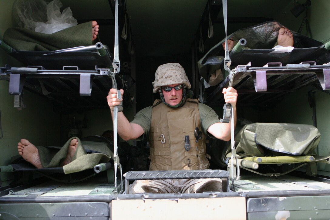 The sailors and Marines of Taqaddum Surgical must be prepared for any task such as escorting injured U.S. and Iraqi troops to waiting helicopters when a mass casualty incident occurs. Petty Officer 3rd Class Jesse K. Bolstad, a 32-year-old native of Spokane, Wash., holds on tightly as the ambulance he is in prepares to leave Taqaddum Surgical. The staff of Taqaddum Surgical, the main facility of its kind in the region, treated several soldiers of the Iraqi Army after a recent insurgent attack. The Iraqi unit had several wounded in the attack that also hit two American service members attached to its Military Transition Team. Taqaddum Surgical is classified as a surgical shock trauma platoon because it has two main elements: a shock trauma platoon, which serves as an emergency room, and a forward resuscitative surgical suite â?? a battlefield operating room. The MTT is a small group of American military personnel tasked with training and advising the Iraqi soldiers as they take control of their country.
