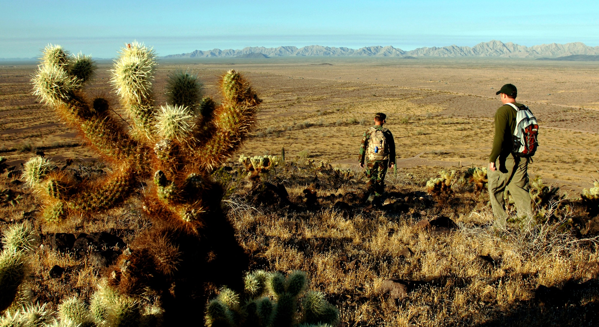 Maj. Daniel Garcia and J.T. Hesse navigate a rocky path on a hill at the Barry M. Goldwater Range in Phoenix, Ariz., where they supervise pronghorn monitoring. Once no sign of the antelope is found, mission bombings and strafing can continue on the range. Mr. Hesse is the wildlife biologist and Major Garcia is the chief of environmental science at the 56th Range Management Office. (U.S. Air Force photo/Tech. Sgt. Cecilio M. Ricardo Jr.)