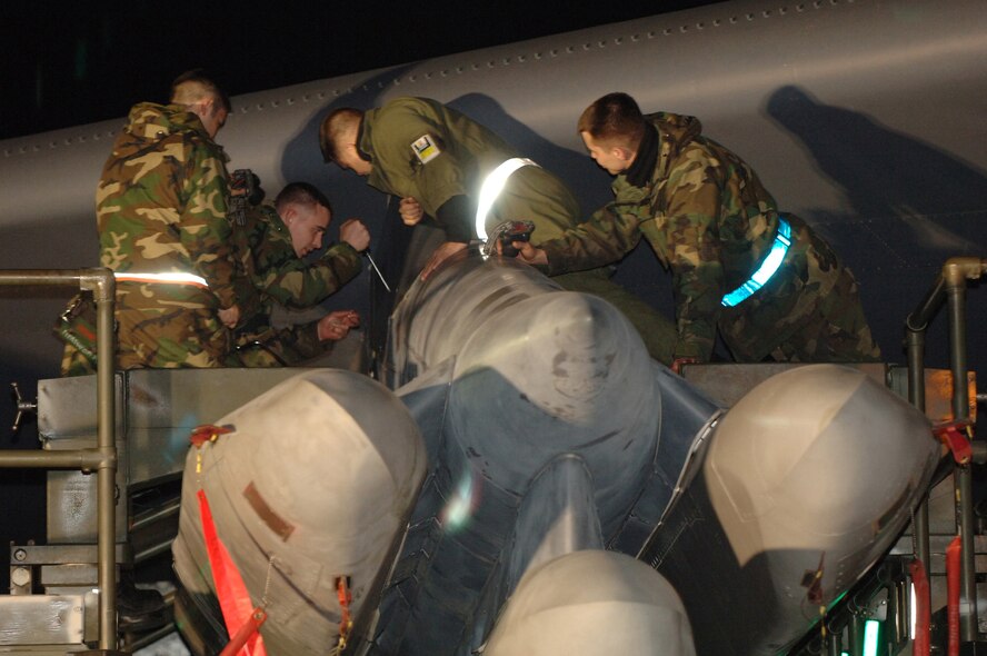Weapons loaders from the 5th Maintenance Group work through the night loading cruise missiles onto B-52H Stratofortress here April 21 during a generation exercise testing the base's ability to respond to national objectives. (U.S. Air Force photo by Senior Airman Stacy Moless)