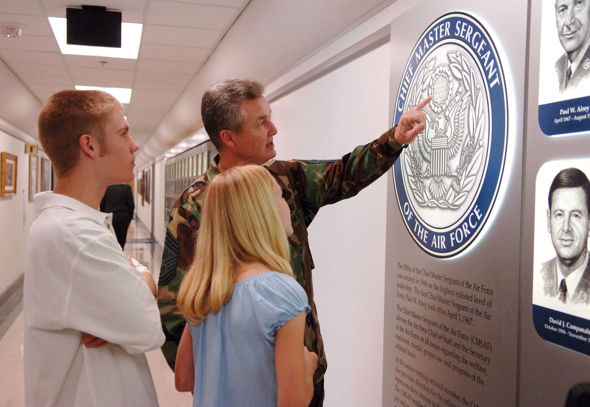 Chief Master Sgt. of the Air Force Gerald R. Murray explains the significance of each part of the emblem outside his Pentagon office to his daughter Elizabeth, 10, and his son Stephen, 17, on Thursday, April 27, 2006. Chief Murray brought Elizabeth and Stephen to the Pentagon for the National Take Our Daughters and Sons to Work Day. (U.S. Air Force photo/Master Sgt. Jim Varhegyi)