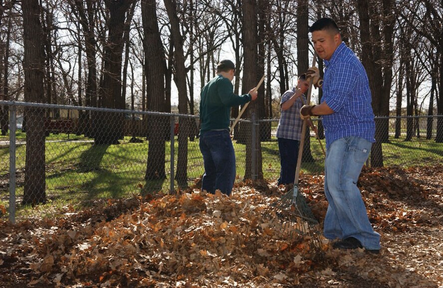 Airman 1st Class Michael Balmaceda, 91st Missile Security Forces Squadron, rakes leaves as a volunteer to help with spring clean-up of Oak Park in Minot April 25. (U.S. Air Force photo by Staff Sgt. Jocelyn Rich)