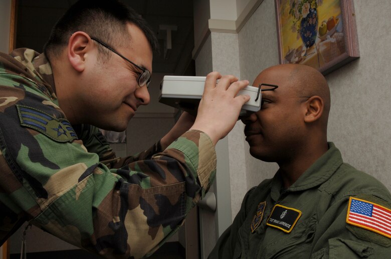 FAIRCHILD AFB, Wash. --Senior Airman Nemesio Perez, 92nd Aeromedical-Dental Squadron optometry technician, checks the eyes of Tech. Sgt. Brian Lawrence, 92nd ADS Aerospace Physiology training flight NCOIC. (U.S. Air Force Photo by Airman Nancy Hooks.)