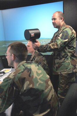 FAIRCHILD AFB, Wash. -- Senior Airman Travis Speakman and Airman 1st Class Joshua Hollenbeck, 92nd Operations Support Squadron air traffic controllers, complete a training session in the tower’s simulator, while Senior Master Sgt. Brian Lavoie, 92nd OSS control tower chief, points the light gun. Sergeant Lavoie was selected by the Spokane Regional Chamber of Commerce as the 2005 Person of the Year in the senior enlisted category. (U.S. Air Force Photo by Airman Nancy Hooks.)