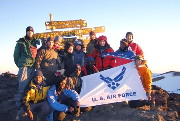 The Seven Summits Challenge team and two of their guides take a break in front of Mount Kilimanjaro July 12 at 13,000 feet, Day 3 of their ascent. They reached the summit July 16 at 6:30 a.m. (Courtesy photo)
