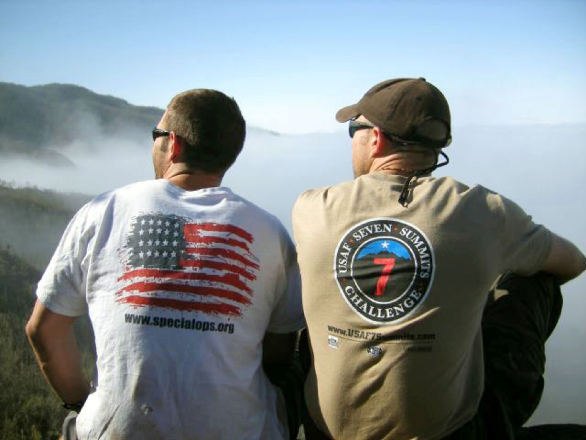 1st Lt. Mark Uberuaga (left) and Capt. Rob Marshall gaze upwards toward the summit of Mount Kilimanjaro during a break on Day 2 of their ascent. Lieutenant Uberuaga wears the Special Operations organization T-shirt, and Captain Marshall wears the T-shirt he designed for the Seven Summits Challenge. The men gave T-shirts to their climbing guides. (Courtesy photo/Capt. Nichelle Brokering) 