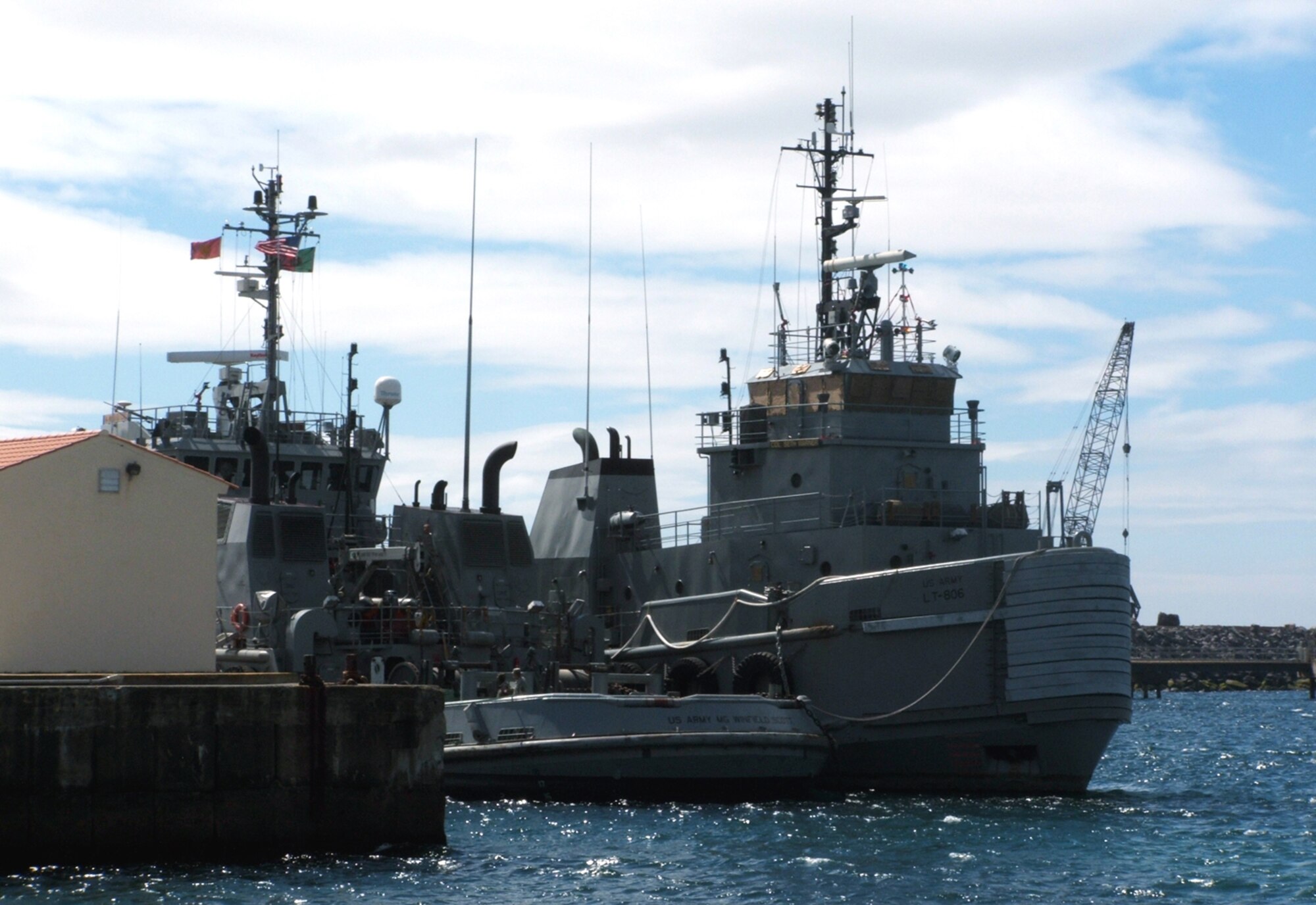 The U.S. Army tugboat Major General Winfield Scott leaves with its ship in tow, the Colonel Seth Warner, on Aug. 1 after being docked at the military port in Praia da Vitoria, Azores, since July 28. Airmen from the 65th Air Base Wing at Lajes Field provided re-supply and refueling support to the Army tugboat by converting an aircraft refueler to support a ship. (U.S. Air Force photo/Staff Sgt. Marcus McDonald) 
