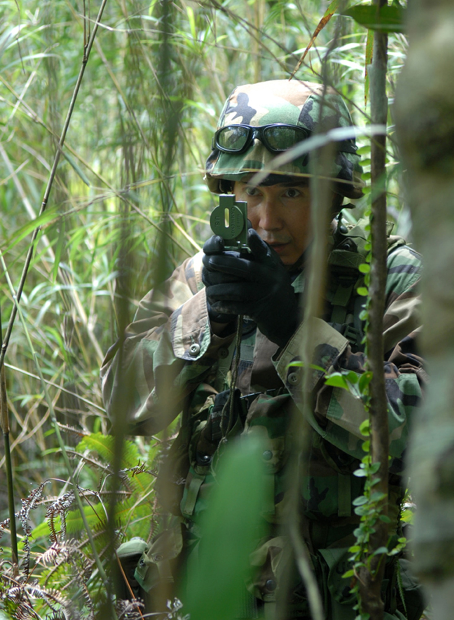First Lt. Christopher Stob uses his compass on his team's first navigation mission during a weeklong training course at the Jungle Warfare Training Center at Camp Gonsalves, Okinawa, on July 25. Thirty Airmen from the 18th Communications Squadron at Kadena Air Base, Japan, attended the course, which included land navigation and other skills, culminating in an endurance course on the final day. The 18th CS is the first non-combat support unit to go through this training. (U.S. Air Force photo/Senior Airman Jeremy McGuffin) 
