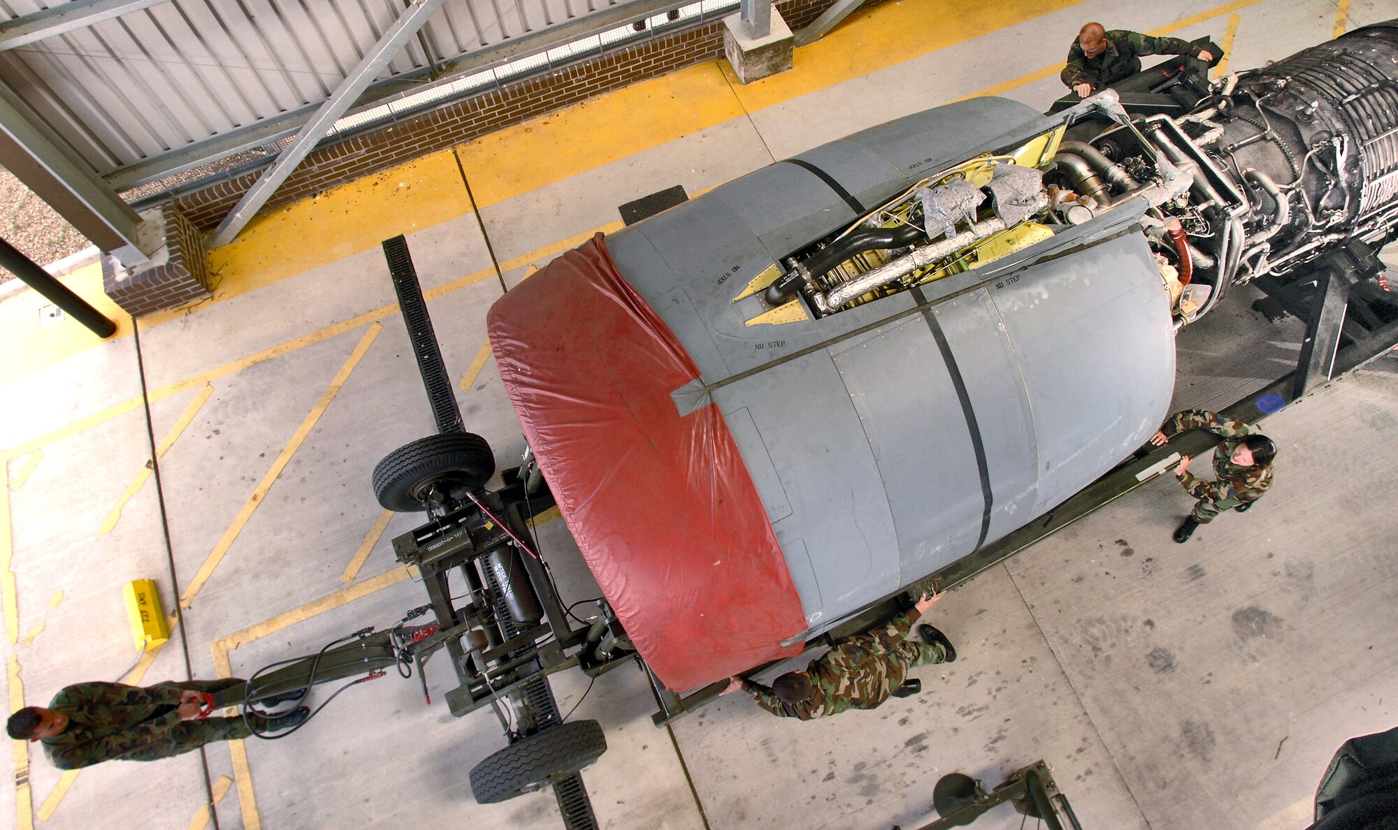 Staff Sgt. Erik Lucas and (left to clockwise) Tech. Sgt. Douglas Younts, Staff Sgt. Abbi Cabeen and others position a turbofan engine into a storage facility at Royal Air Force Mildenhall, England, on July 31. The 727th Air Mobility Squadron keeps and maintains spare C-5 Galaxy engines in case a visiting transport needs an engine swap. Each engine produces 43,000 pounds thrust, weighs 7,900 pounds and is nearly 27 feet long. (U.S. Air Force photo/Master Sgt. Lance Cheung) 