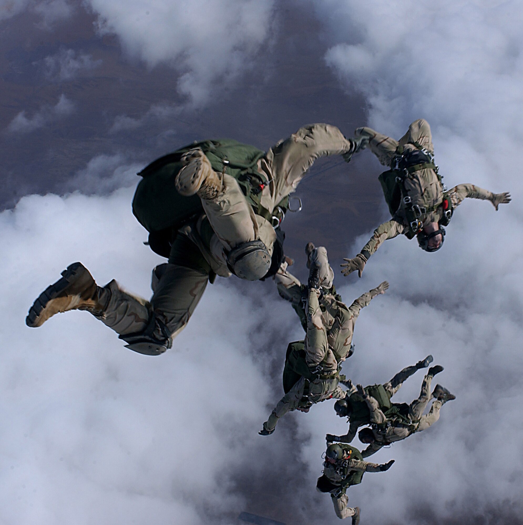 Pararescue men from the 38th Rescue Squadron, Moody AFB, GA and the 58th Rescue Squadron, Nellis AFB, NV jump from a C-130 for a High Altitude Low Opening (HALO) free fall drop from 12999 feet in support of Operation Enduring Freedom. PJs use a variety of jumps depending on the mission.  (U.S. Air Force Photograph by Staff Sgt. Jeremy T. Lock)