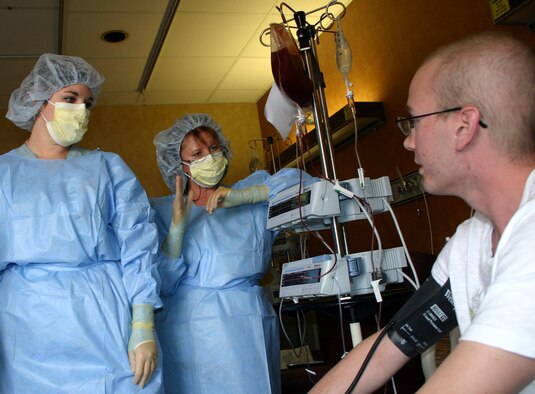(From left) 2nd Lt. Joanna Moore and Tonia Beltran explain the bone marrow transplant procedure to Army Sgt. Joe DeLashmutt at Wilford Hall Medical Center, Lackland Air Force Base, Texas, on July 7. The bone marrow, a thick, red bloodlike substance, is given intravenously. The nurses are bone marrow transplant nurse specialists. (U.S. Air Force photo/Master Sgt. Kimberly Spencer) 
