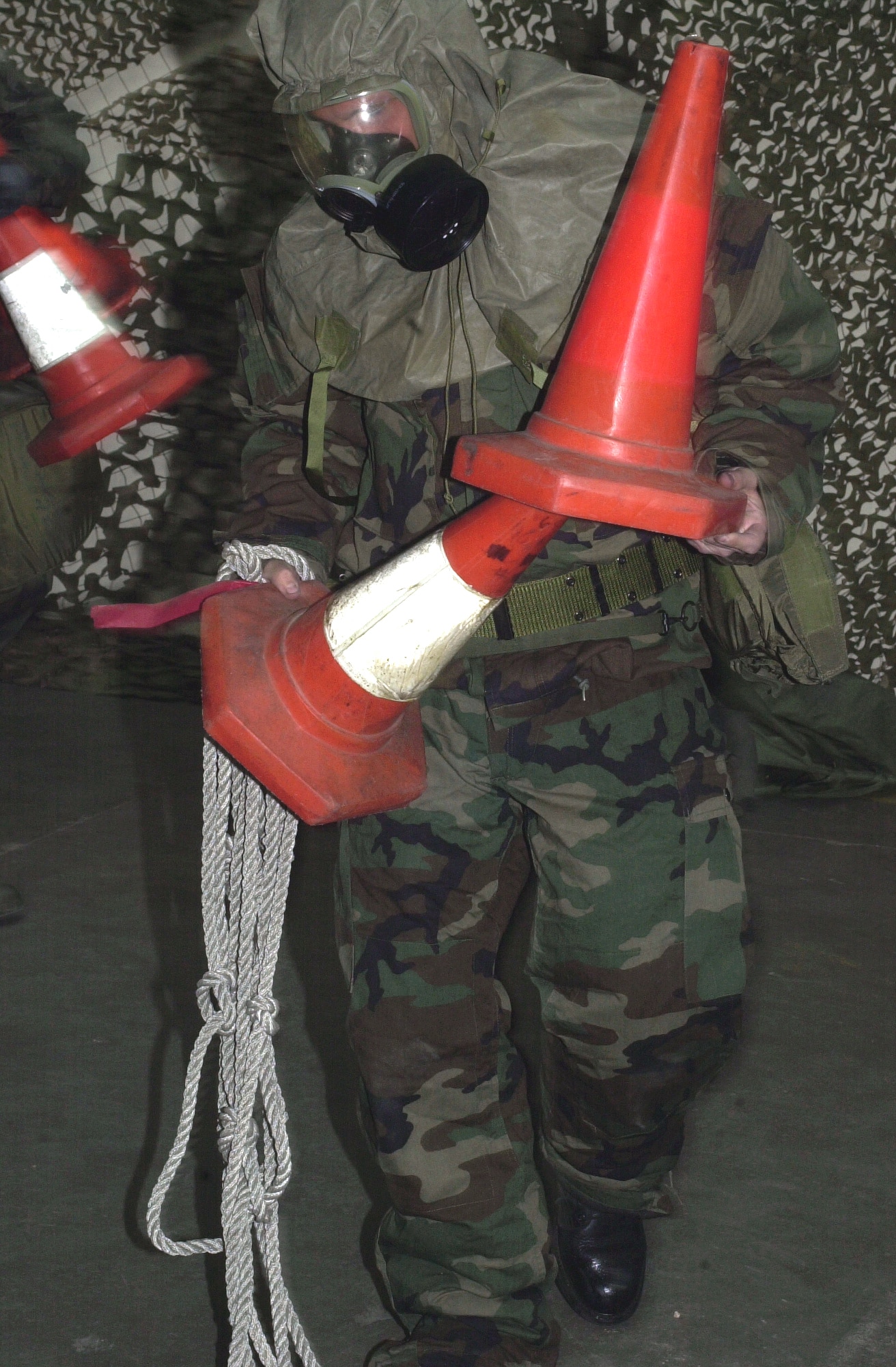 Senior Airman Thomas Nightingale, 100th Aircraft Maintenance Squadron crew chief, simulates cordoning off a contaminated vehicle during the exercise portion of a Chemical, Biological, Radiological, and Nuclear Defense Training class held here. (U.S. Air Force photo by Geoff Janes)