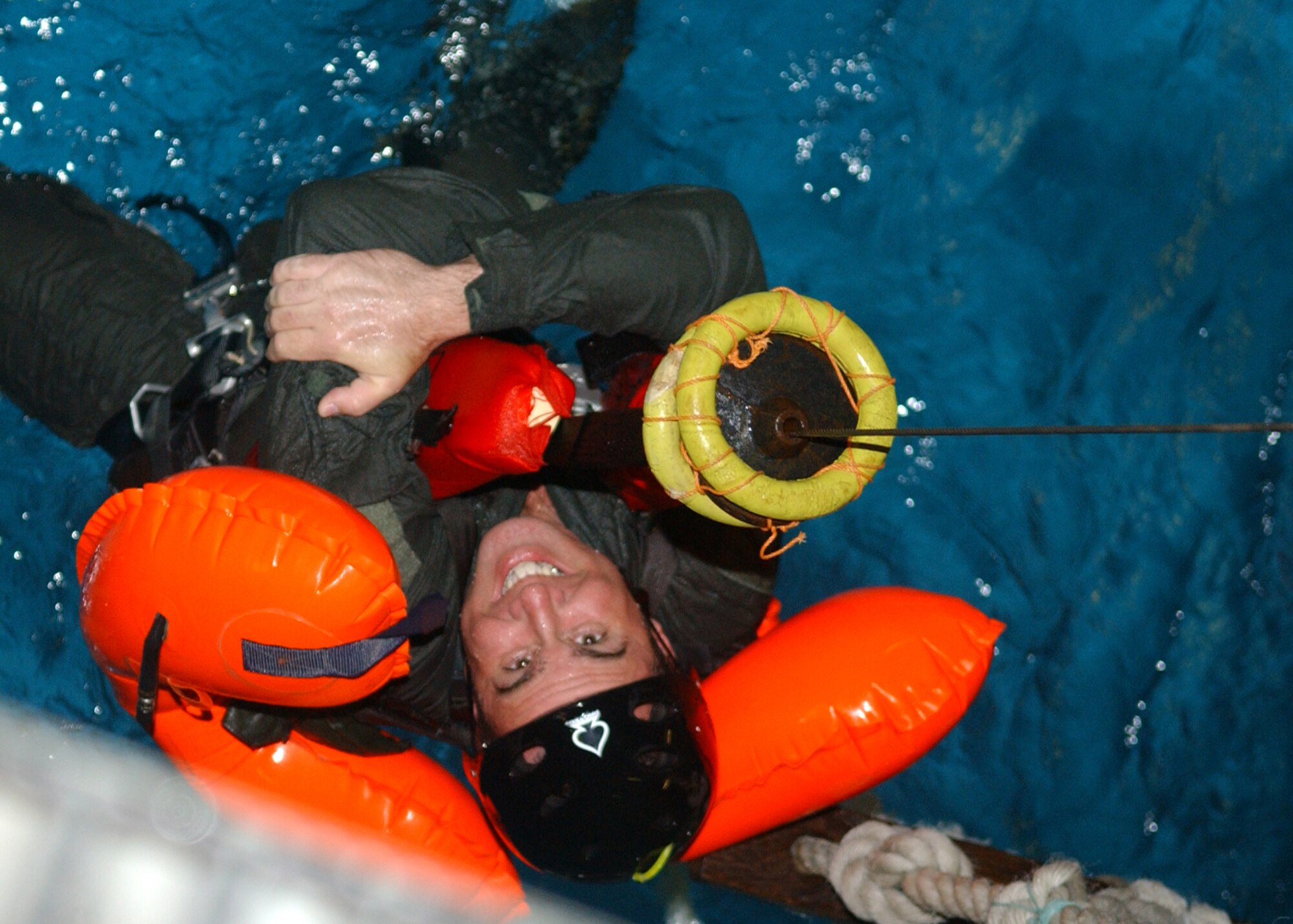 Master Sgt. Brian Weil, a radio operator and first sergeant for the 67th Special Operations Squadron, holds on as a hoist lifts him out of a pool June 8 at Lowestoft College during water-survival training. He is practicing what to do in the event he is rescued by a helicopter after an aquatic aircraft crash.  (U.S. Air Force photo by Staff Sgt. Tyrona Pearsall)