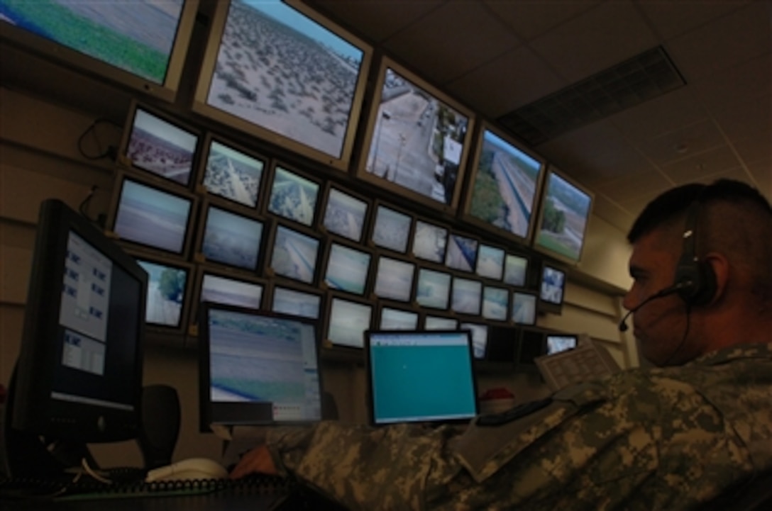 U.S. Army Spc. Joseph Prieto watches a row of monitors in the communications department of the Yuma Sector Border Patrol Station in Arizona on July 27, 2006.  Prieto is assigned to the Wisconsin Army National Guard, which will be patrolling the Arizona-Mexico border with the Border Patrol in support of Operation Jump Start.  
