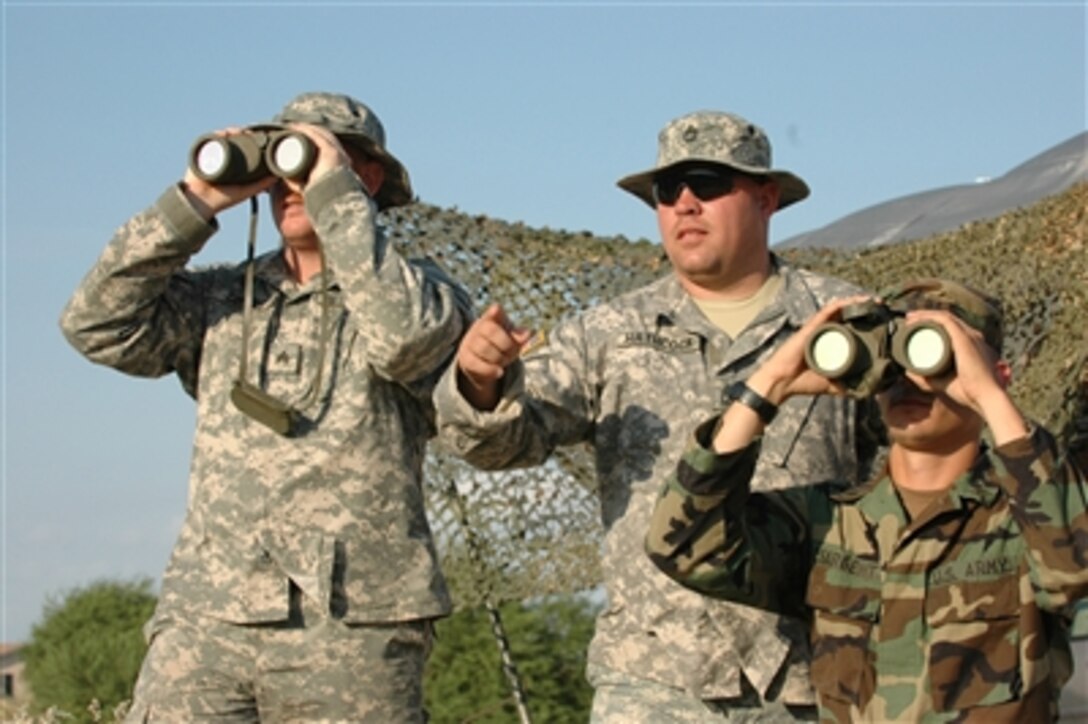 U.S. Army Sgt. 1st Class Cary Hathcock (center) points to an area of the U.S.-Mexican border in San Luis, Ariz., as Sgts. David Cortes (left) and Fletcher Sergent scan the area for any movement on July 30, 2006.  More than 200 North Carolina National Guard soldiers are currently working with the U.S. Border Patrol in support of Operation Jump Start.  