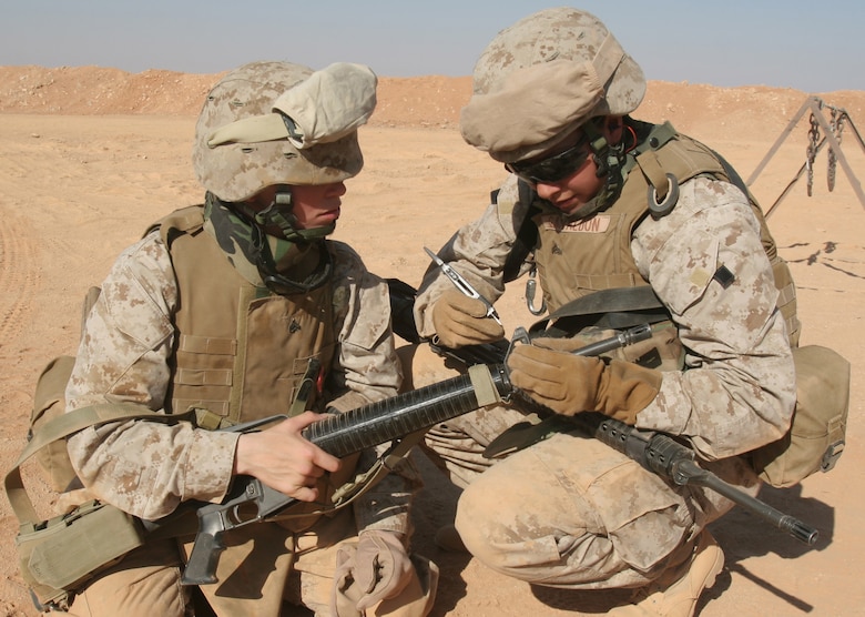 Cpl. Valerie Gavaldon (right) helps Cpl. Roxanne Cox (left) adjust the front site post on her M16A2 service rifle, during the live-fire portion of their training at Camp Korean Village, Iraq, July 31. Eight female Marines from different units within 3rd Marine Aircraft Wing volunteered for the Lioness Program to conduct security searches of women crossing into Iraq. Gavaldon is a combat engineer, Marine Wing Support Squadron 274, Marine Wing Support Group 37 (Reinforced), 3rd MAW, and an El Paso, Texas native. Cox is a maintenance management specialist with Marine Aircraft Group 16 (Reinforced), 3rd MAW, and a Cincinnati native.