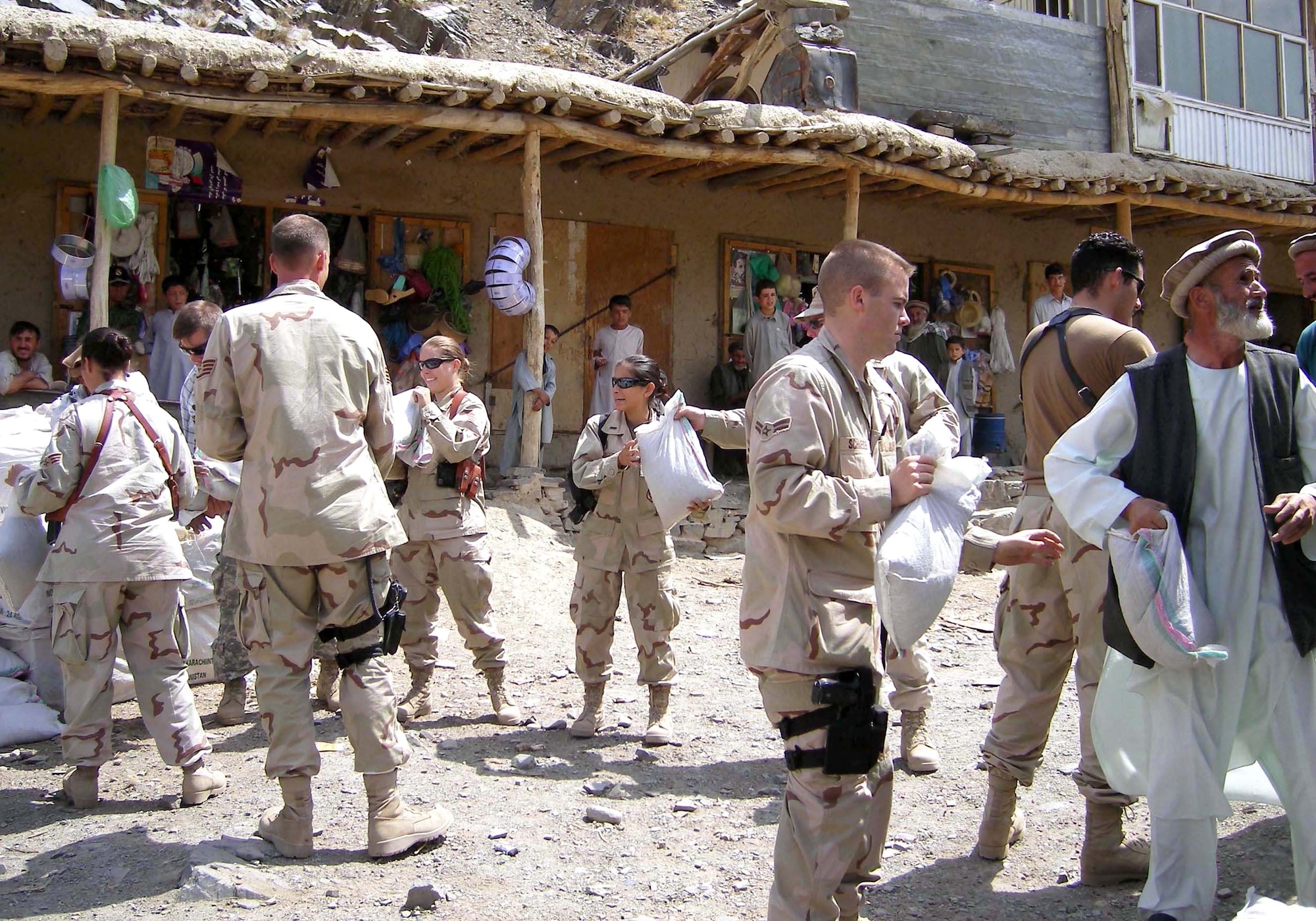 Members of the Panjshir Provincial Reconstruction Team and volunteers unload a 5-ton truckload of humanitarian assistance food supplies near Abdara, Afghanistan, on July 30. More than 180 Afghan locals are building a road by hand to connect three villages to the main road across the Panjshir River. Governor Haji Bahlol requested assistance for workers who are unable to provide for their families while building the road. The PRT also plans to provide tool kits with shovels, picks, hammers and other hand tools to assist with the project. (Courtesy photo/Shahla Hammond) 
