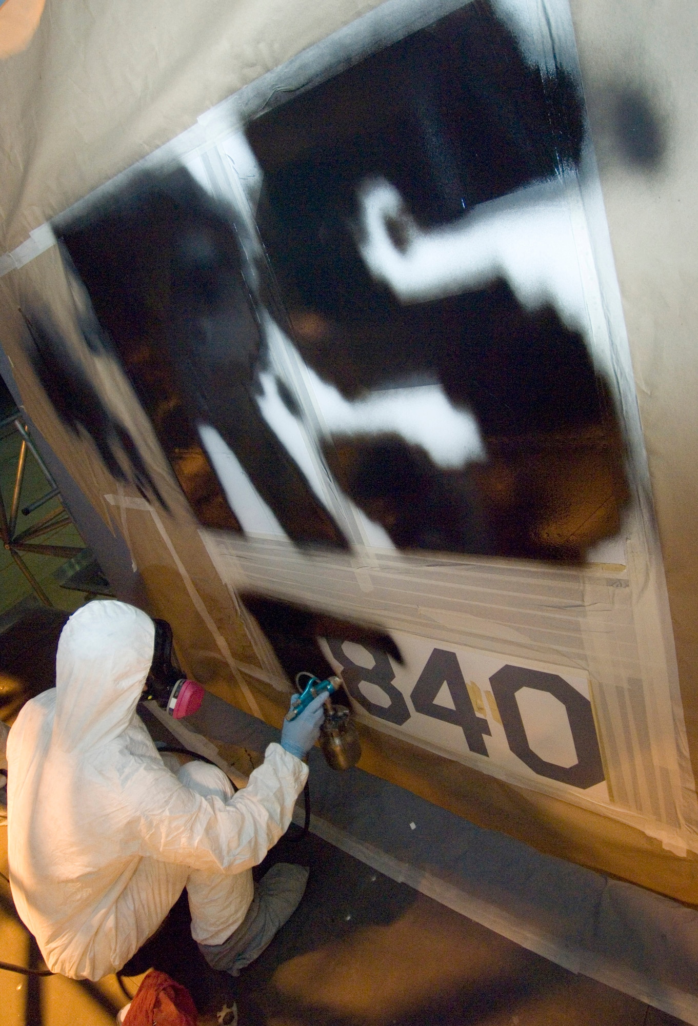Senior Airman Steve Essler spray paints the tail number on the tail of one of two C-130 Hercules on July 31 that have been assigned to the 37th Airlift Squadron at Ramstein Air Base, Germany. Airman Essler is an aircraft structural maintainer with the 86th Maintenance Squadron. (U.S. Air Force photo/Master Sgt. John E. Lasky)