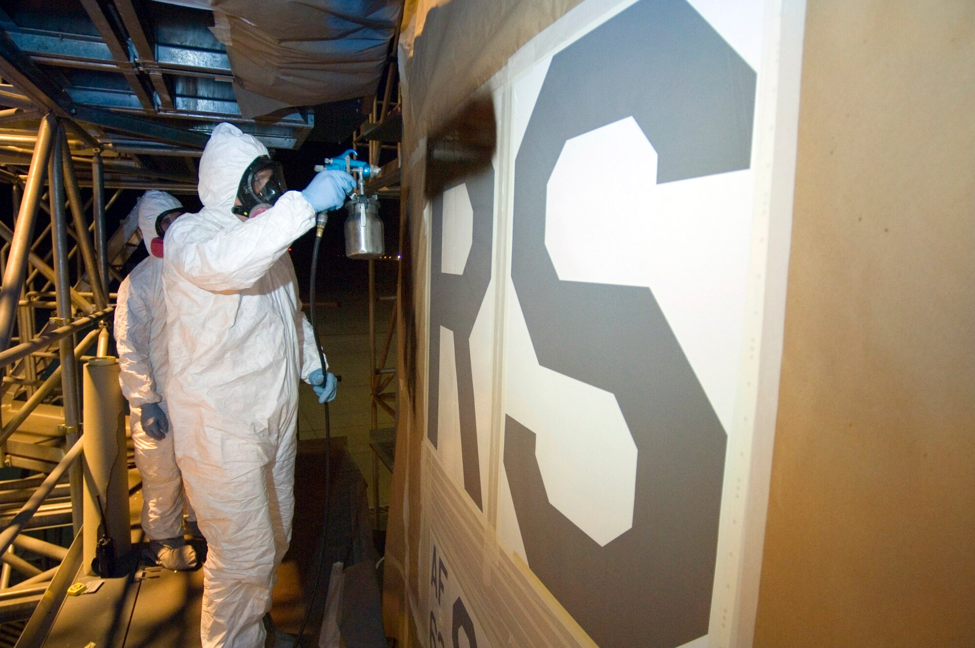 Staff Sgt. John Zentner paints "RS" on the tail of one of two C-130 Hercules on July 31 that have been assigned to the 37th Airlift Squadron at Ramstein Air Base, Germany. Sergeant Zentner is an aircraft structural maintainer with the 86th Maintenance Squadron. (U.S. Air Force photo/Master Sgt. John E. Lasky)