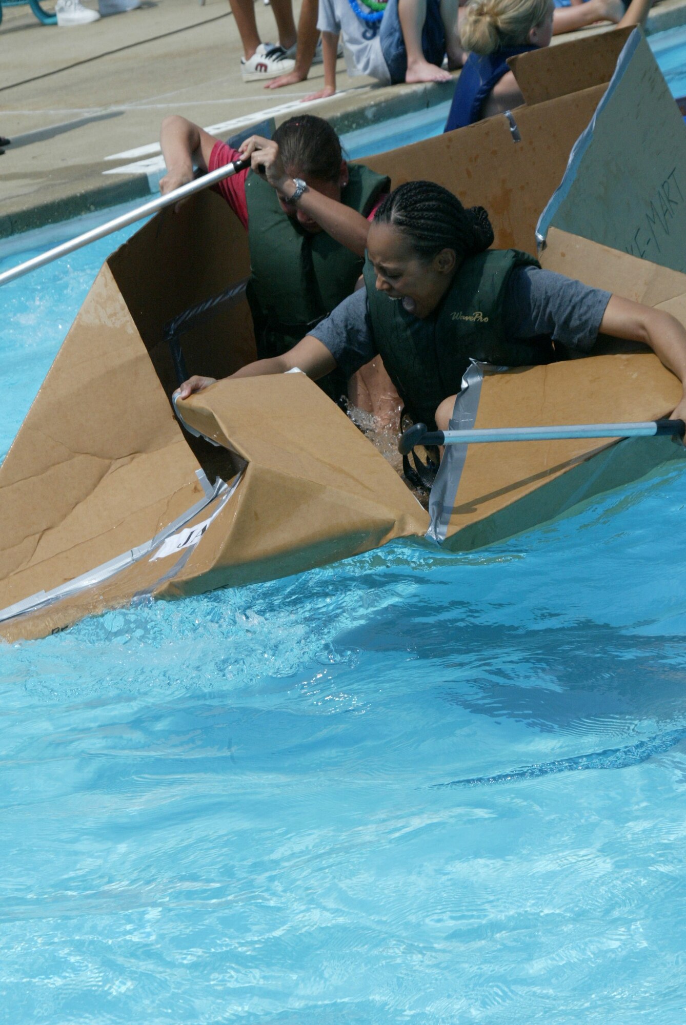 Capt. Nina Padalino and Staff Sgt. Roilina Stewart, 43rd Airlift Wing Legal Office, struggle to keep their boat afloat during the race. They were able to navigate their boat across the pool, but took on water and weren?t able to make it back. (U.S. Air Force photo/Lisa Terry McKeown)