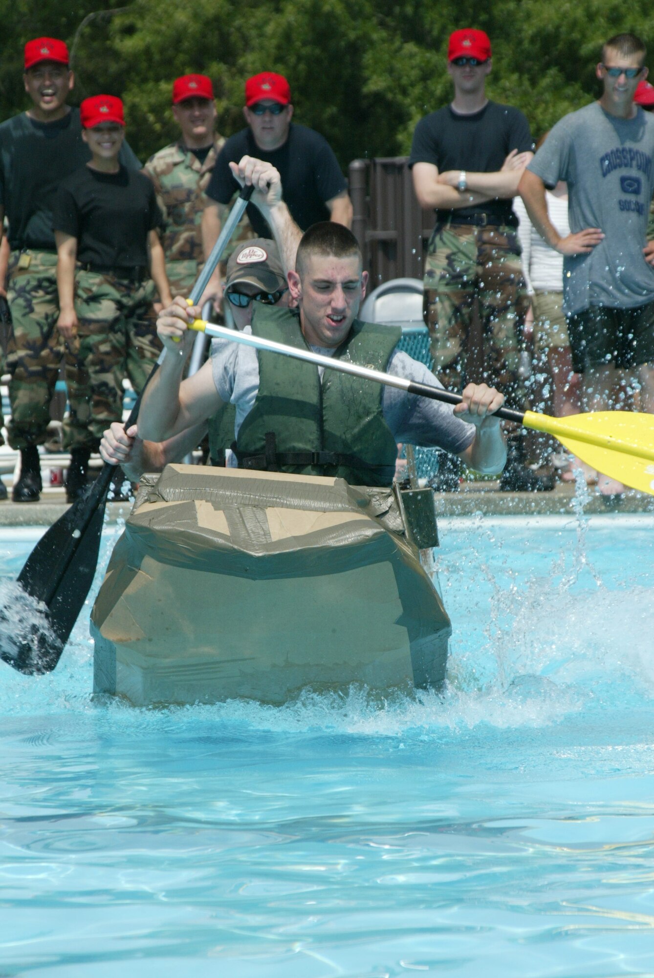 Tech. Sgt. Seth Abel and Airman 1st Class Jason Bullock, 3rd APS, paddle their boat to victory while being cheered on by their fellow Airmen. The 3rd APS received $200 with their 1st place trophy. (U.S. Air Force photo/Lisa Terry McKeown)