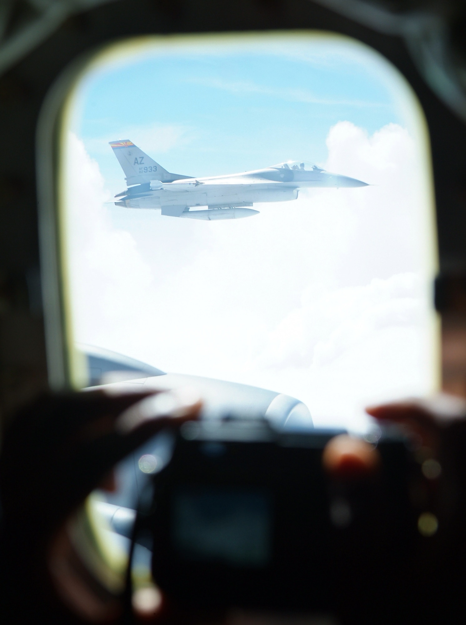A Civil Air Patrol cadet takes a photo of an F-16 Fighting Falcon during an incentive flight on a KC-135 Stratotanker for students in the CAP and Aviation Careers Education Camp in Phoenix on Aug. 1. The camp was held in conjunction with the Tuskeegee Airmen Convention. Both aircraft are with the Arizona Air National Guard. (U.S. Air Force photo/Tech. Sgt. Joe Zuccaro) 
