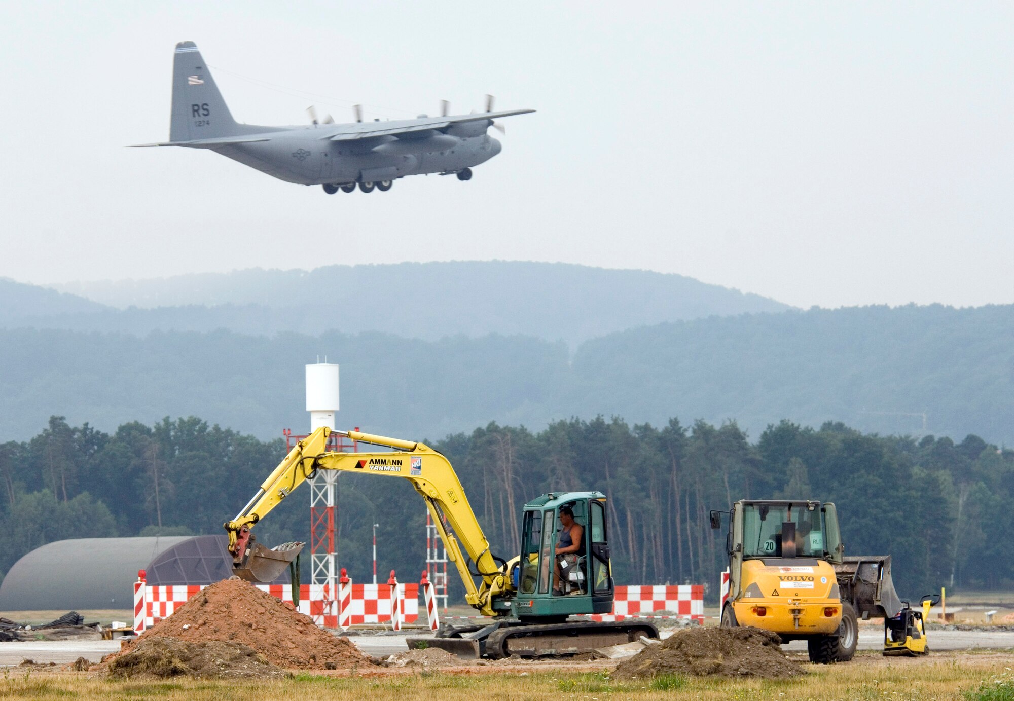 A C-130 Hercules uses the south runway as construction continues on the north runway at Ramstein Air Base, Germany, on July 28. The north runway will be extended 1,000 feet, allowing heavy air transports to take off fully loaded. The work began in mid-April and is one week ahead of the Jan. 1 completion date. (U.S. Air Force photo/Master Sgt. John E. Lasky) 
