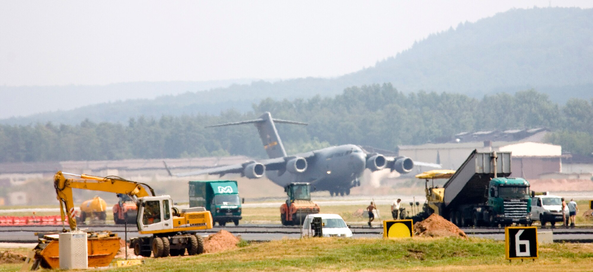 A C-17 Globemaster III lifts off from the south runway as construction continues on the north runway at Ramstein Air Base, Germany, on July 28. The north runway will be extended 1,000 feet, allowing heavy air transports to take off fully loaded. The work began in mid-April and is one week ahead of the Jan. 1 completion date. (U.S. Air Force photo/Master Sgt. John E. Lasky) 

