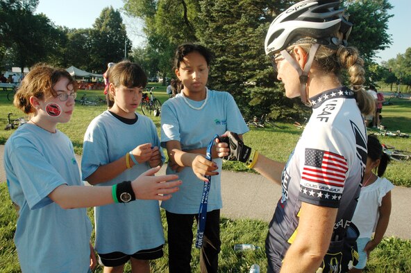 Lt. Col. Sheila Marcusen hands out Air Force promotional materials to girls in West Branch, Iowa, on July 29. The colonel was a member of the Air Force team taking part in the Des Moines Register's Annual Great Bike Ride Across Iowa. The Air Force team of cyclists participates in RAGBRAI in support of recruiting. Colonel Marcusen is with the U.S. Transportation Command at Scott Air Force Base, Ill. (U.S. Air Force photo/1st Lt. Kristen Duncan) 
