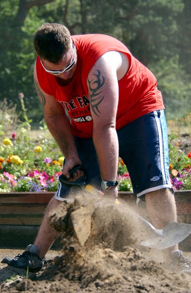Senior Airman Jeremiah Jones, a 100th Civil Engineer Squadron structures technician, puts his shovel to good use while volunteering at the Glade Community Primary School in Brandon July 17. The project consisted of building a vegetable patch for the gardening club and a wildlife area for the minibeast (insect) club prior to the start of the new school year in September. (U.S. Air Force photo by Tech Sgt. Jeanette Copeland)