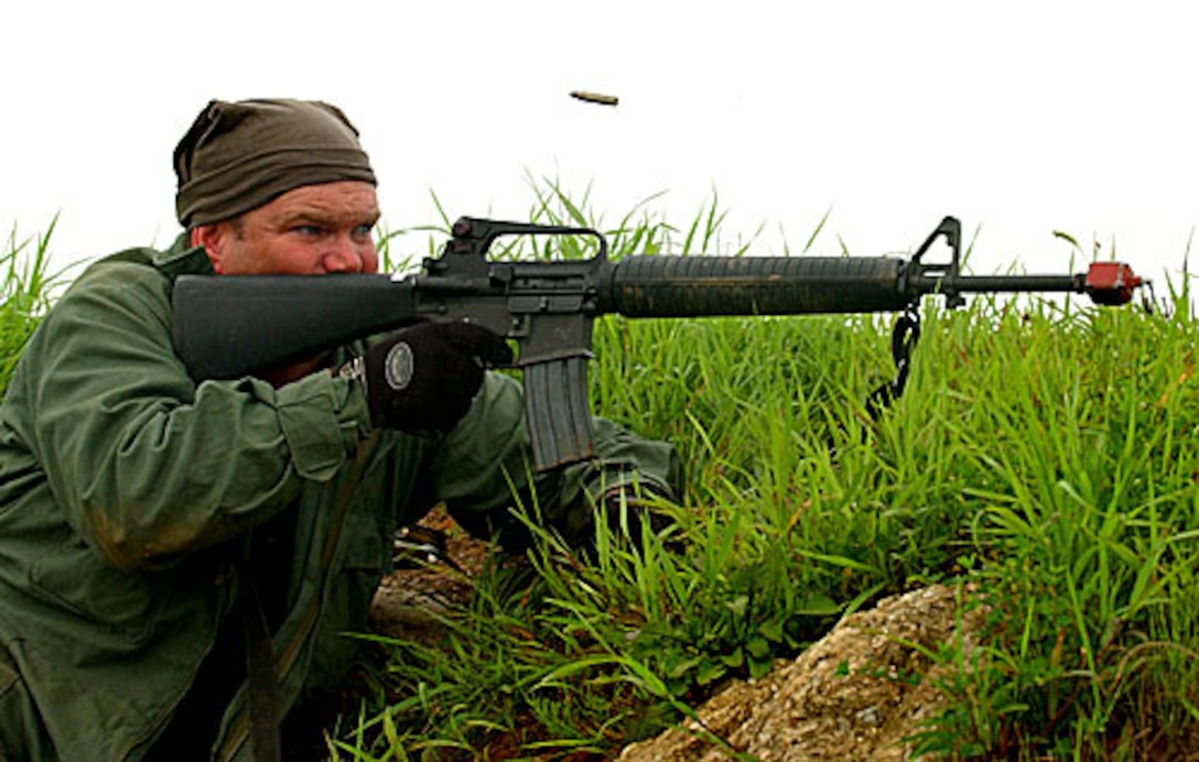 A member of the opposing forces fires his M16 rifle at U.S. Air Force security forces airmen during a simulated attack as part of an exercise at Osan Air Base, South Korea, July 23, 2006.  