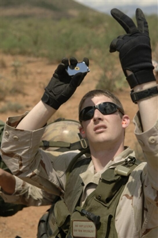 Senior Airman Cody Lefever uses a signaling mirror to alert the pilots of overhead A-10 Thunderbolt II aircraft of his location during a recovery scenario for exercise Angel Thunder near Davis-Monthan Air Force Base, Ariz., on July 26, 2006. Lefever is an Air Force Survival Evasion Resistance Escape specialist.  