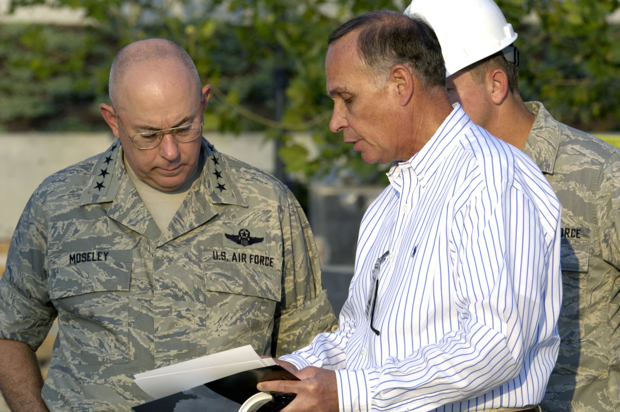 Retired Major Gen. Edward F. Grillo, Jr., Air Force Memorial Foundation president, shows Chief of Staff of the Air Force Gen. T. Michael Moseley and Chief Master Sergeant of the Air Force Rodney J. McKinley the plans of the Air Force Memorial during a visit to the site in Arlington, Va. Aug 3.  The memorial is scheduled to be completed on Oct. 14.(U. S. Air Force photo/Tech. Sgt. Cohen A. Young)