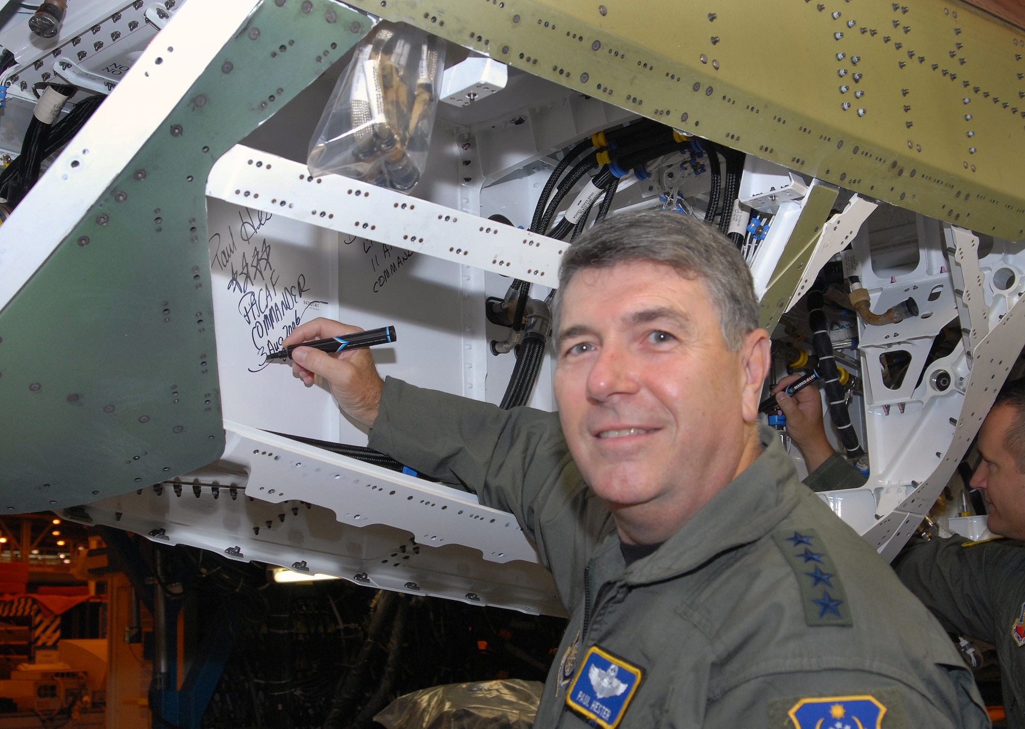 Gen. Paul Hester, Pacific Air Forces commander, signs the tail section of an F-22 Raptor being assigned to PACAF during an unveiling ceremony Aug 3 at the Lockheed Plant in Marietta, Ga.  The aircraft, which is still under construction, will be the first of 36 F-22s assigned to Elmendorf Air Force Base, Alaska, beginning next year.  (Courtesy photo/John Rossino)