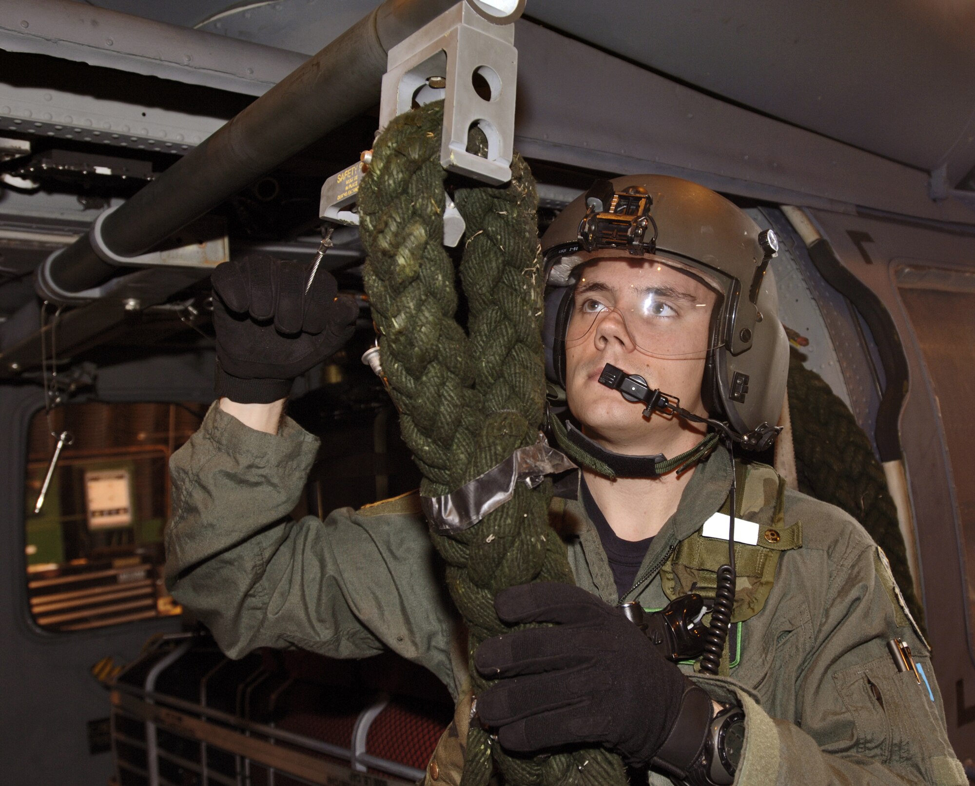 Senior Airman Calvin Paquette attaches a fast rope to an HH-60 Pave Hawk at Royal Air Force Lakenheath, England, on Aug. 2. The aerial gunner is with the 56th Rescue Squadron. The unit moved here from Keflavik Air Base, Iceland, in May. (U.S. Air Force photo/Master Sgt. Lance Cheung)