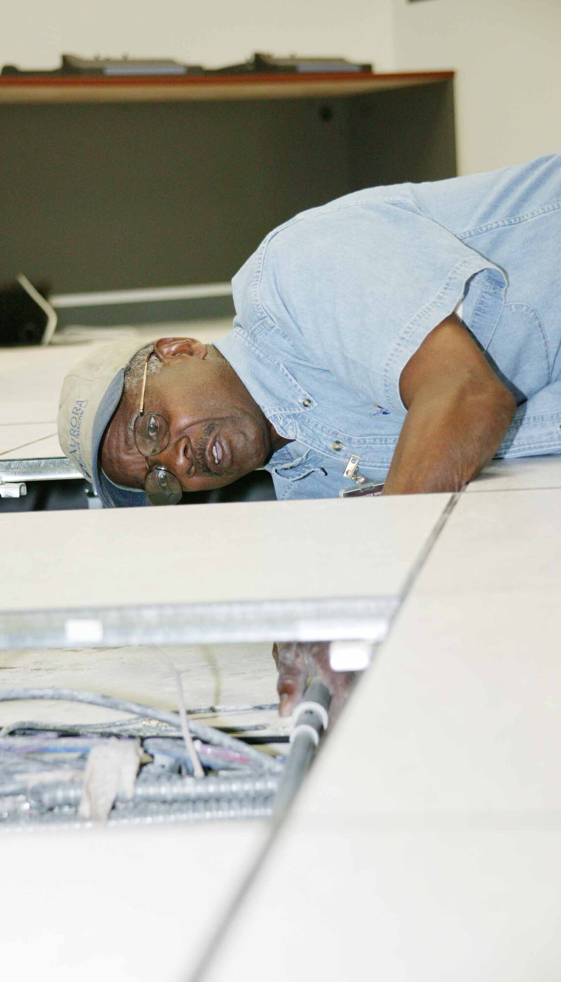 Nolan Bossard, a contracted technician, installs local area network cables recently in the command post as part of a renovation. (U.S. Air Force photo/Tarsha Storey)